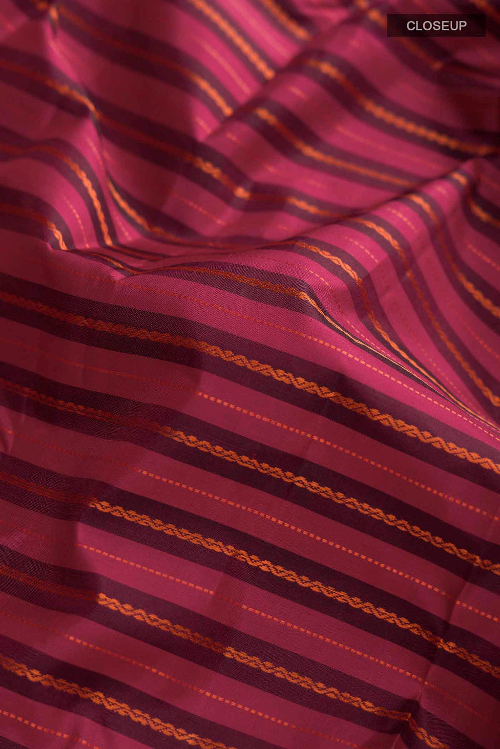 Close up of Maroon Kanchipuram Silk Saree with Stripes on the body and Zari Border displaying folds