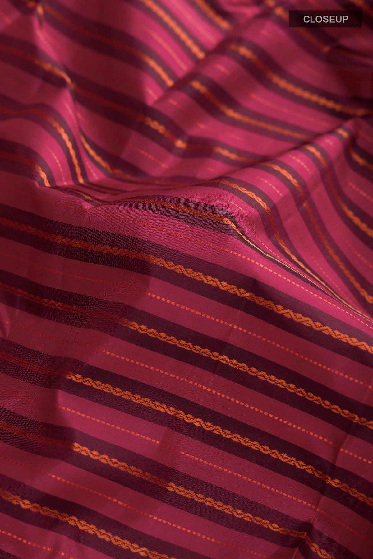 Close up of Maroon Kanchipuram Silk Saree with Stripes on the body and Zari Border displaying folds