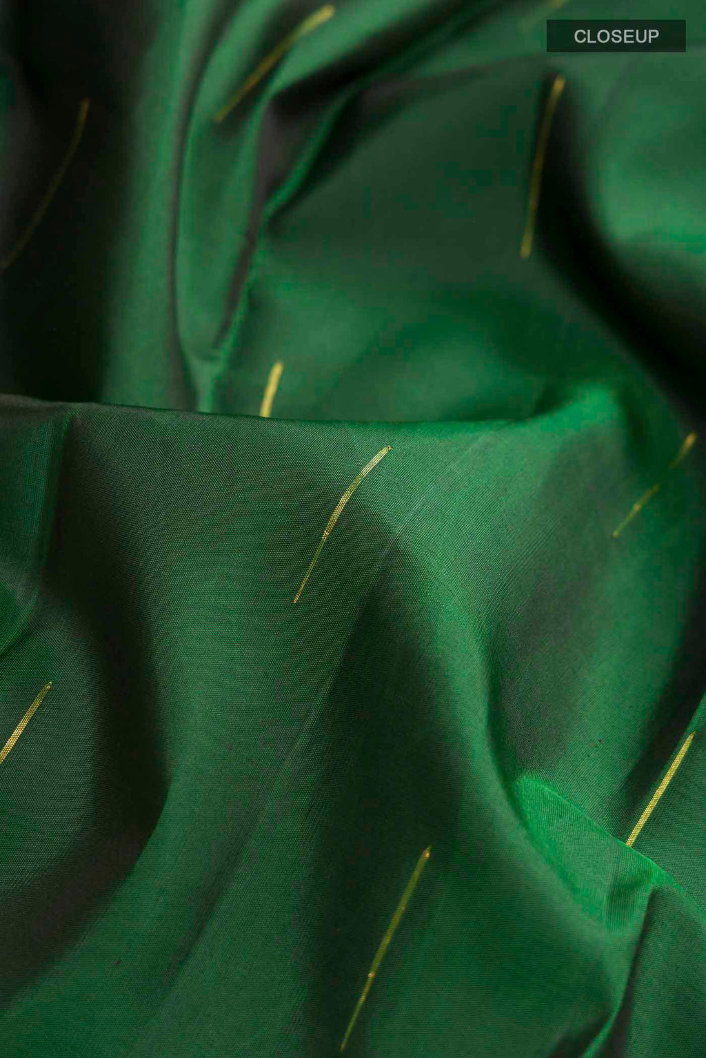Close up of Green Kanchipuram Silk Saree with Zari Butta on the body and Zari Border displaying folds