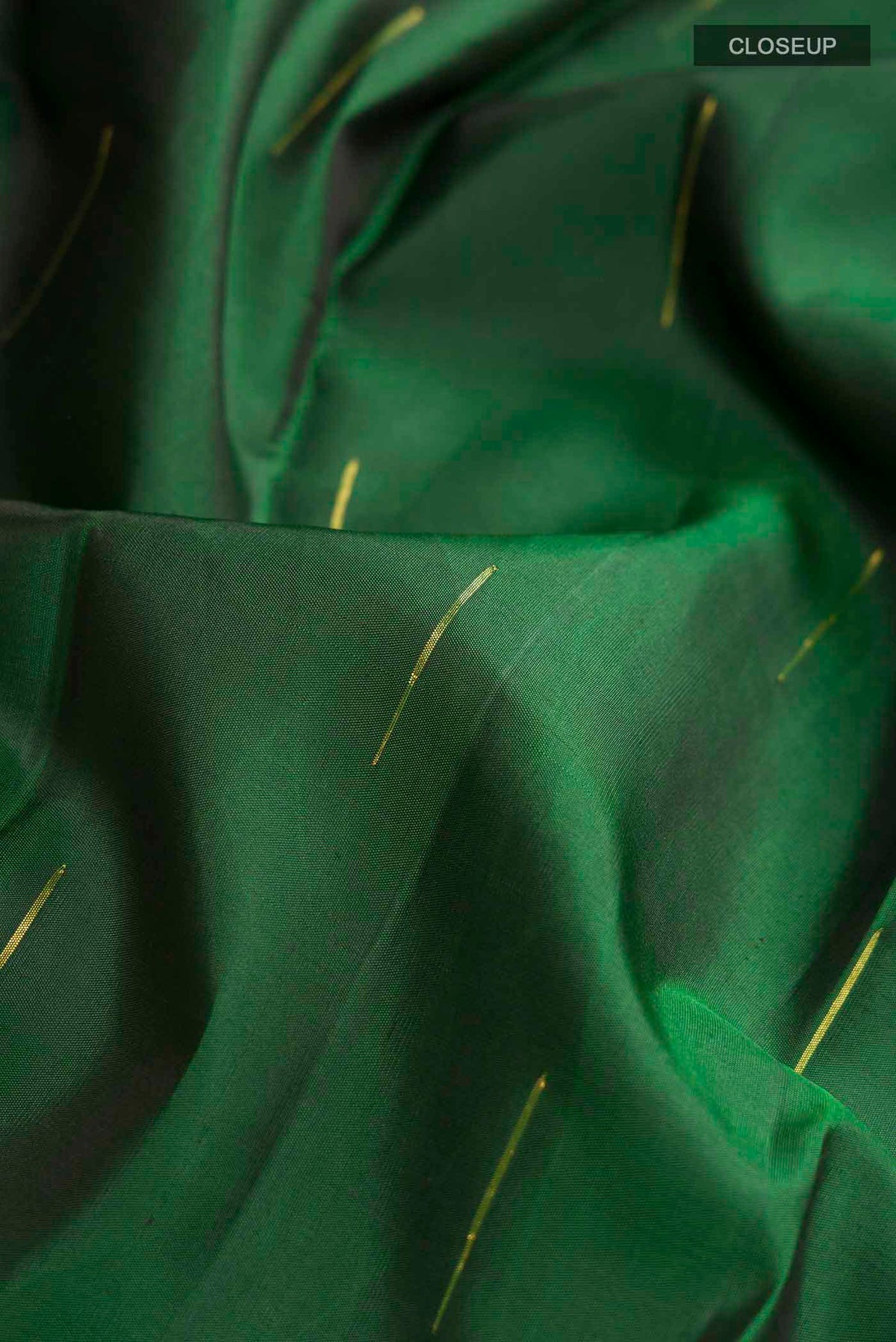 Close up of Green Kanchipuram Silk Saree with Zari Butta on the body and Zari Border displaying folds
