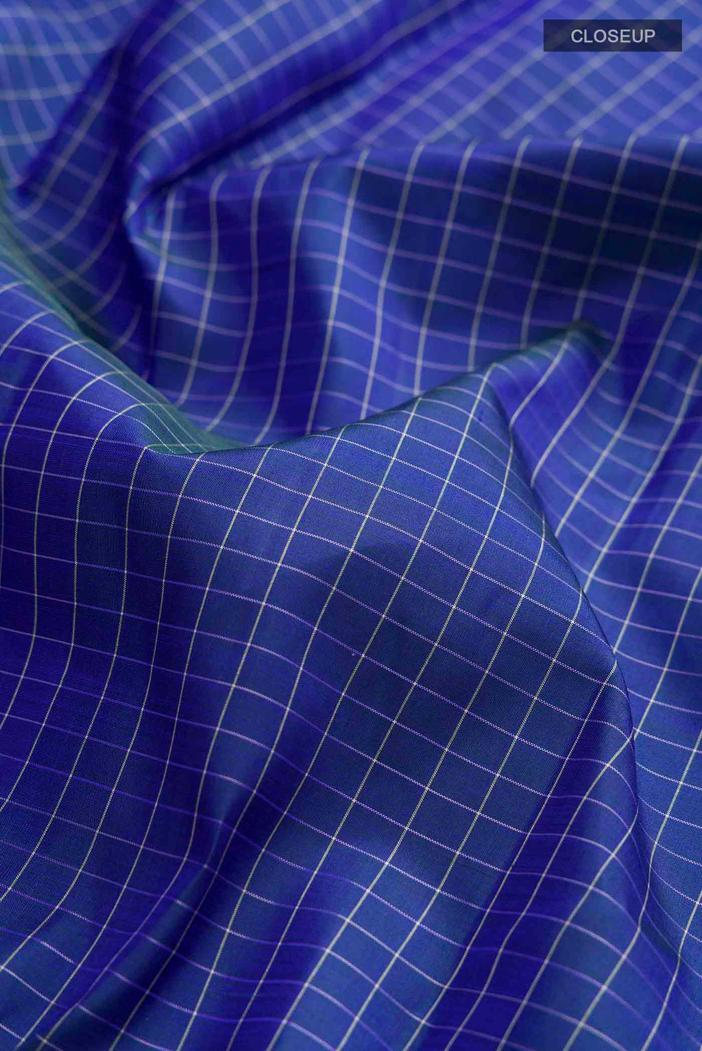 Close up of Blue Kanchipuram Silk Saree with Checked design on the body and Thread Border displaying folds
