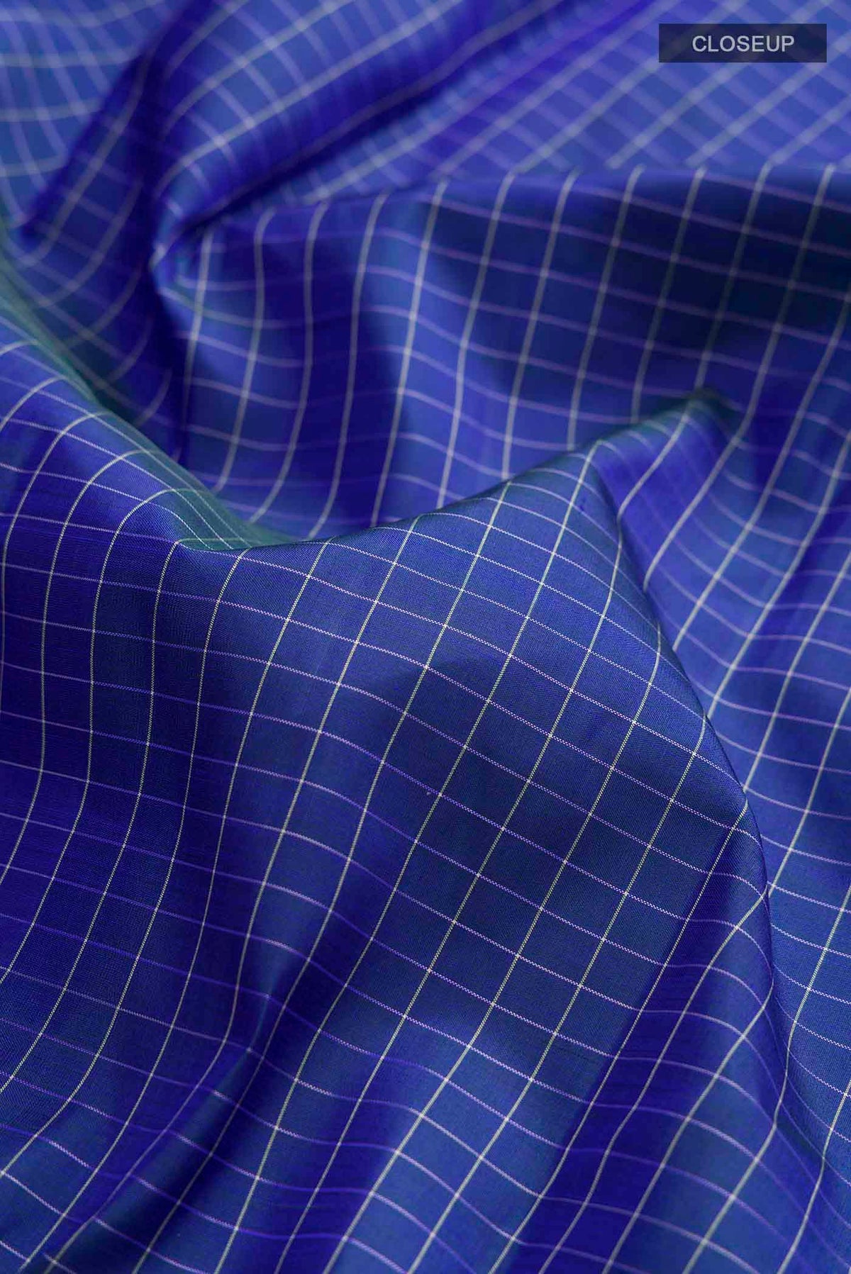 Close up of Blue Kanchipuram Silk Saree with Checked design on the body and Thread Border displaying folds