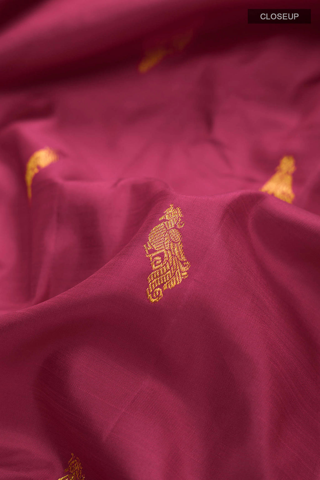 Close up of Maroon Kanchipuram Silk Saree with Zari Butta on the body and Zari Border displaying folds