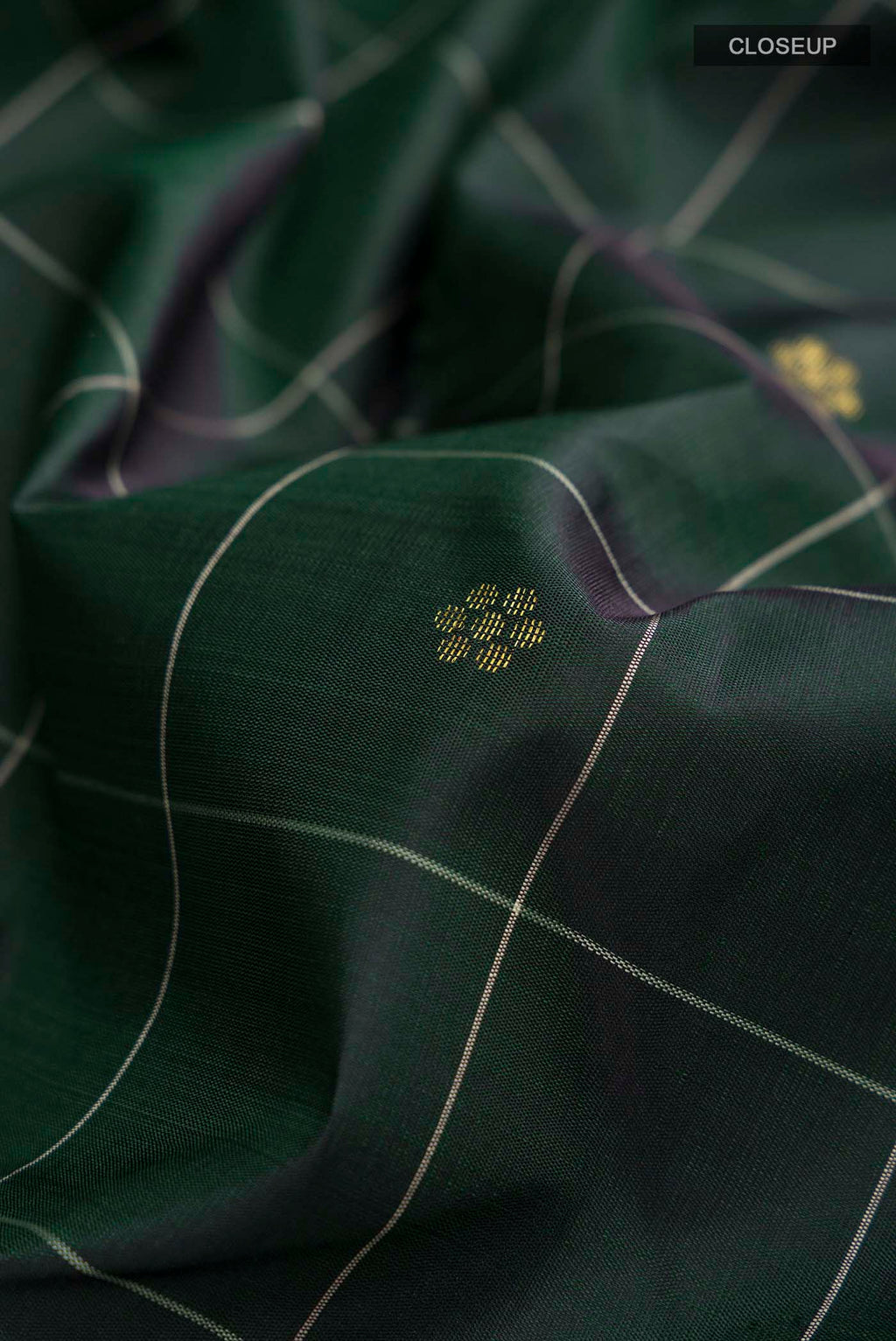 Close up of Green Kanchipuram Silk Saree with Zari Butta on the body and Zari Border displaying folds