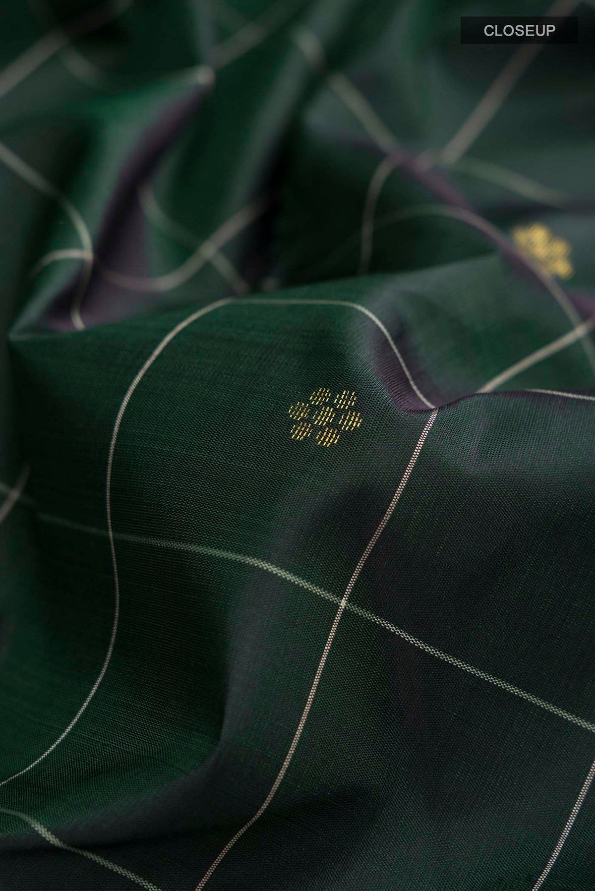 Close up of Green Kanchipuram Silk Saree with Zari Butta on the body and Zari Border displaying folds