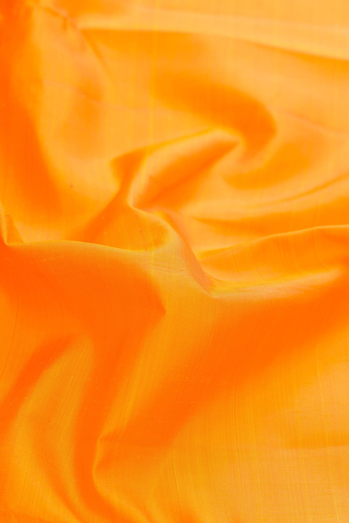 Close up of Pure Silk Pure Zari Orange Dual Tone Kanchipuram Saree with Plain Body and Zari Border displaying folds