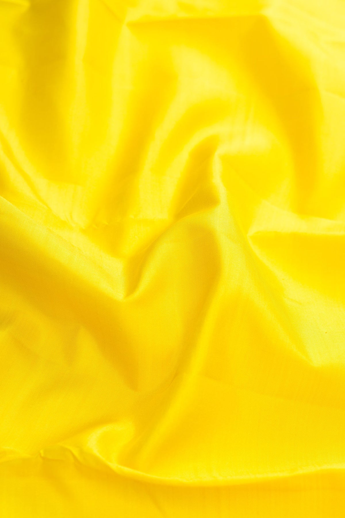 Close up of Yellow Kanchipuram Silk Saree with Plain Body and Thread Border displaying folds