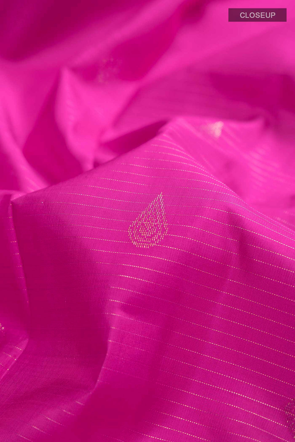 Close up of Pink Kanchipuram Silk Saree with Zari Butta on the body and Zari Border displaying folds