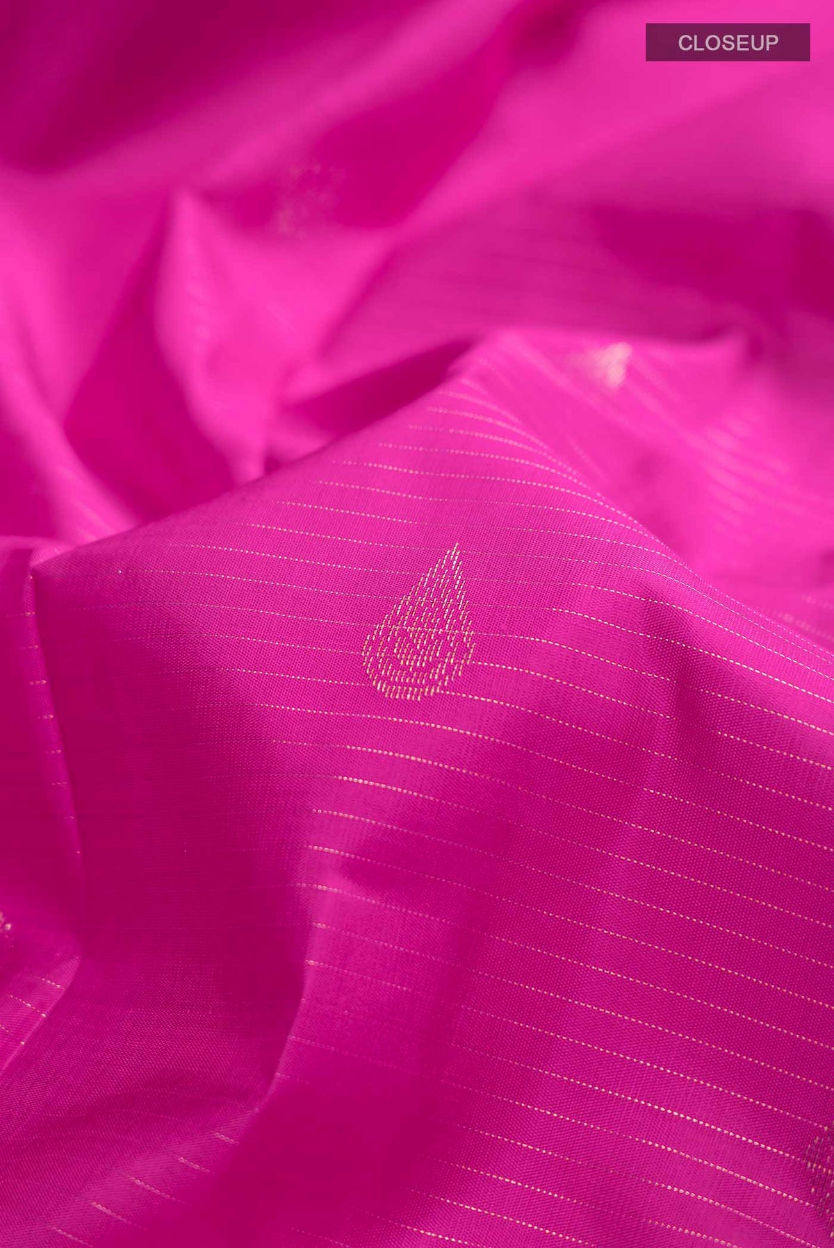 Close up of Pink Kanchipuram Silk Saree with Zari Butta on the body and Zari Border displaying folds