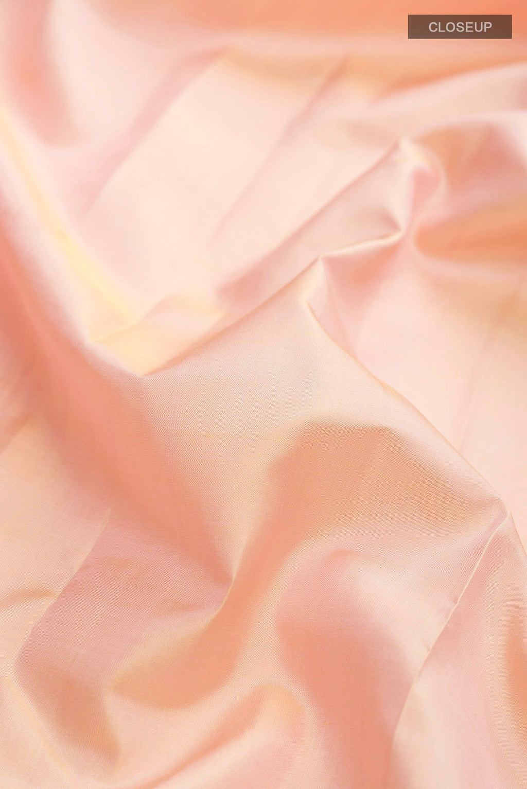Close up of Rose Gold Kanchipuram Silk Saree with Plain Body and Zari Border displaying folds