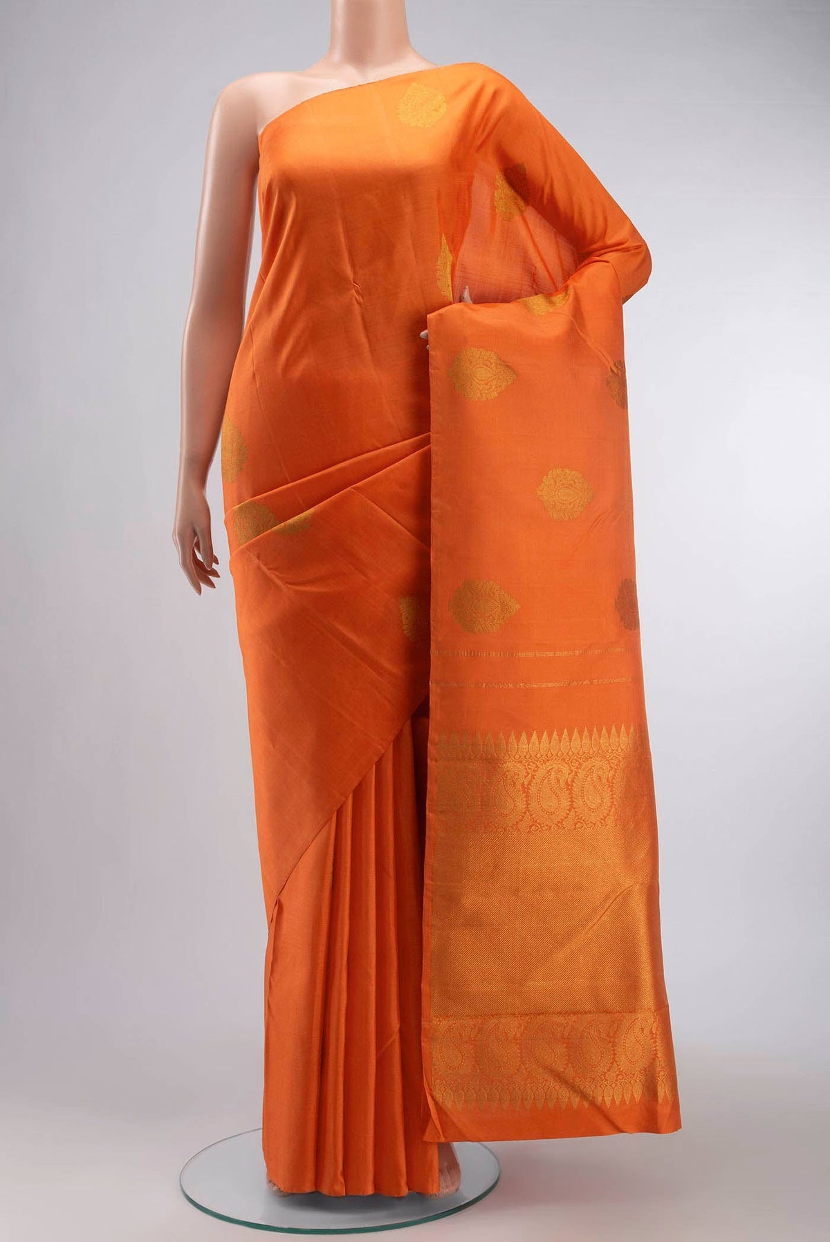 Orange Kanchipuram Silk Saree with Zari Butta on the body and Without Border displayed on a mannequin
