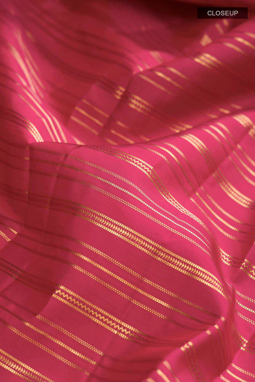 Close up of Maroon Kanchipuram Silk Saree with Stripes on the body and Zari Border displaying folds