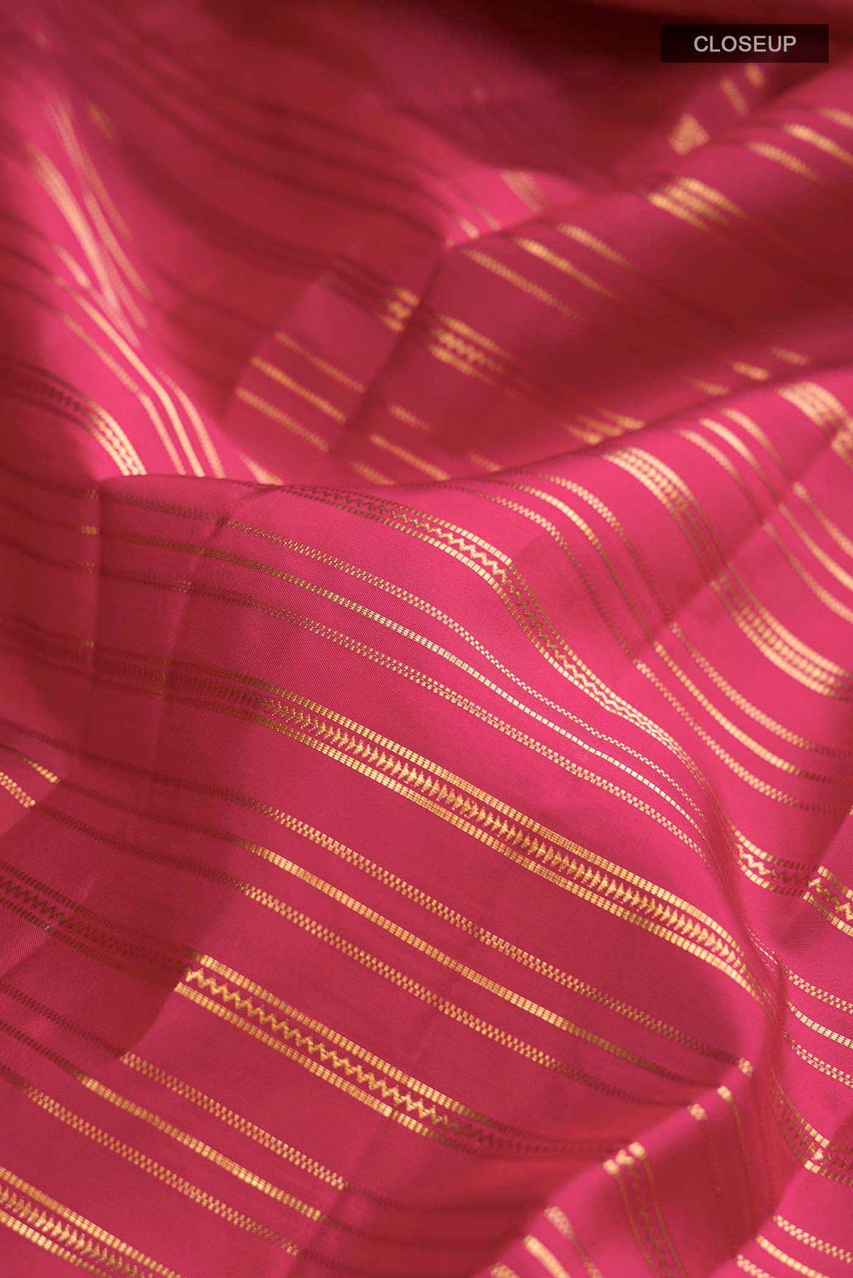 Close up of Maroon Kanchipuram Silk Saree with Stripes on the body and Zari Border displaying folds