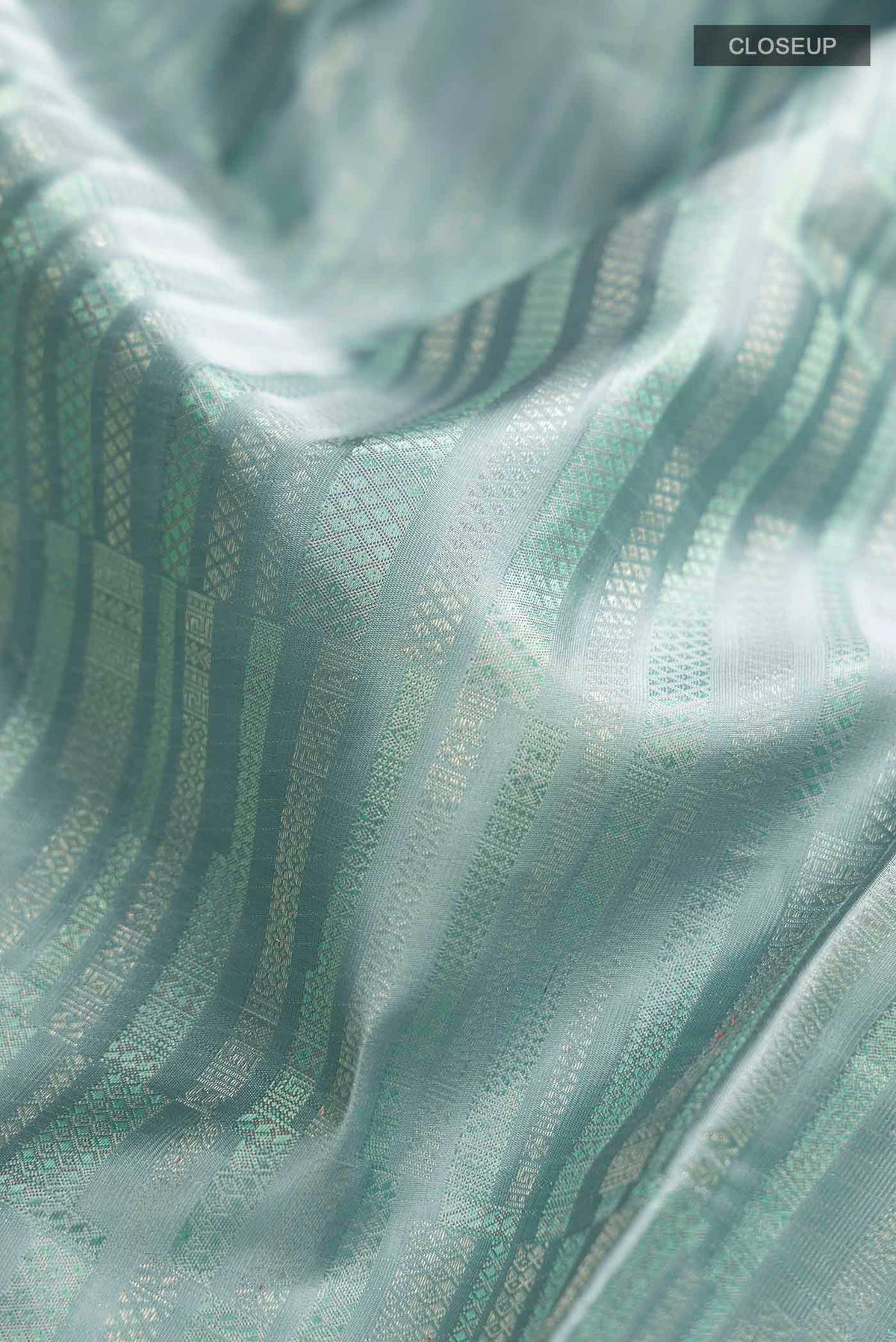 Close up of Blue Grey Kanchipuram Silk Saree with Stripes on the body and Zari Border displaying folds