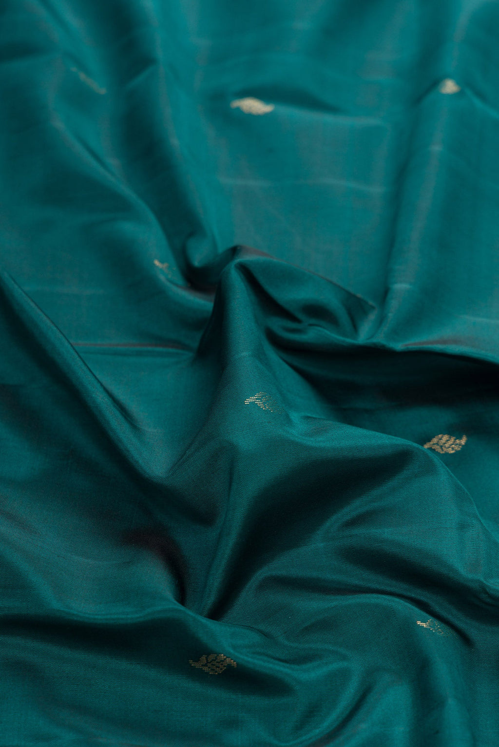 Close up of Maya Blue Dual Tone Kanchipuram Silk Saree with Zari Butta on the body and Zari Border.  displaying folds