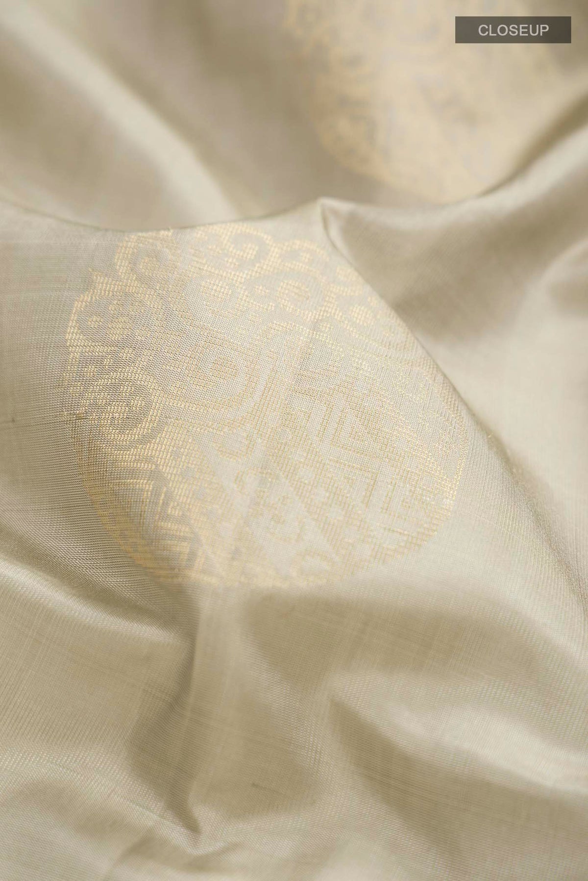 Close up of Green Soft Silk Saree with Zari Butta on the body and Zari Border displaying folds