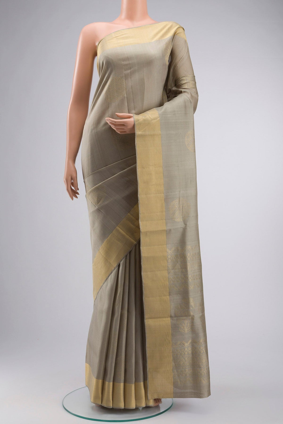 Green Soft Silk Saree with Zari Butta on the body and Zari Border displayed on a mannequin