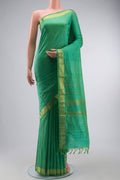Green Kanchipuram Silk Saree with Plain Body and Zari Border displayed on a mannequin