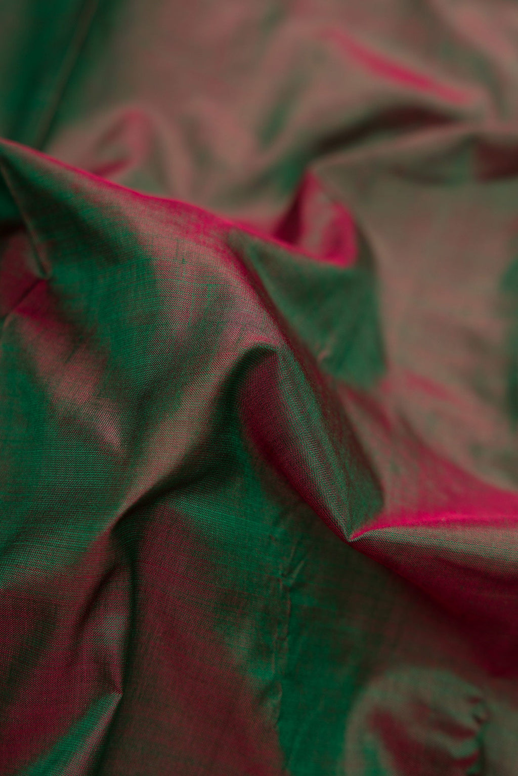 Close up of Green Dual Tone Kanchipuram Silk Saree with Plain Body and Zari Border.  displaying folds