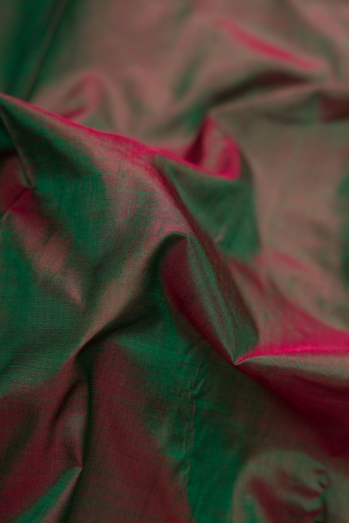 Close up of Green Dual Tone Kanchipuram Silk Saree with Plain Body and Zari Border.  displaying folds