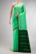 Green Mysore Crepe Saree with Plain Body and Zari Border.  displayed on a mannequin