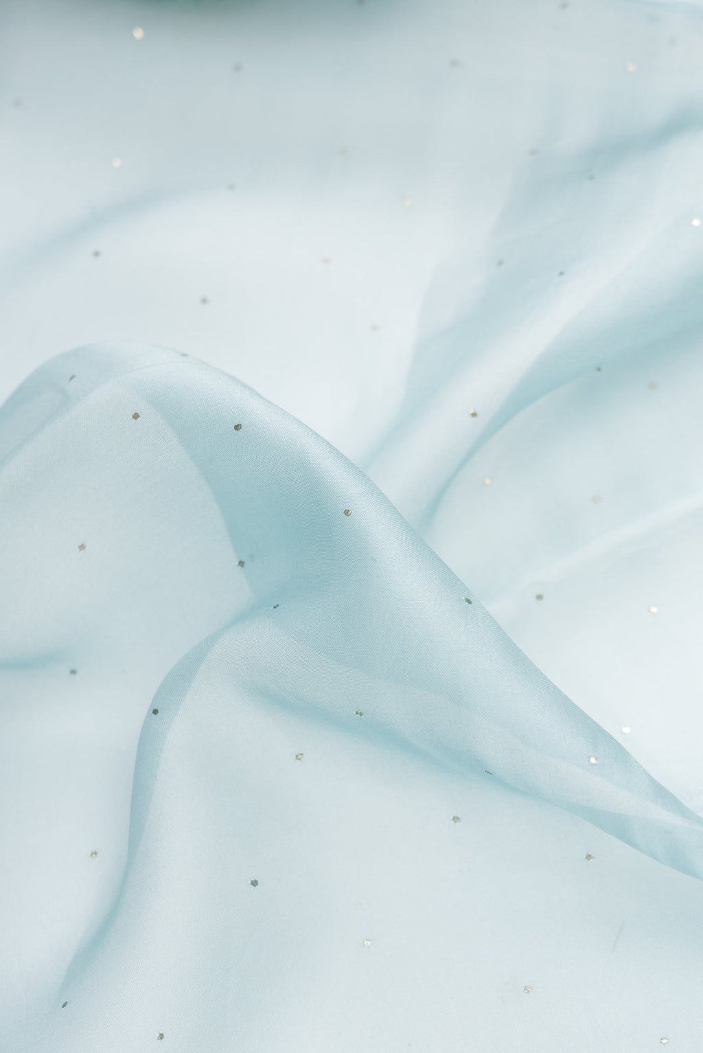 Close up of Sky Blue Dual Tone Organza Silk Saree with Embroidery on the body and Embroidery Border.  displaying folds