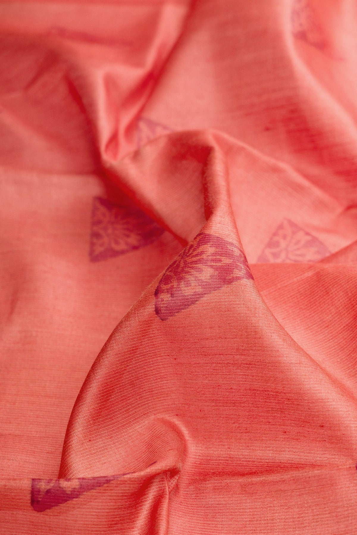 Close up of Brick Orange Dual Tone Tussar Silk Saree with Printed design on the body and Fancy Border.  displaying folds