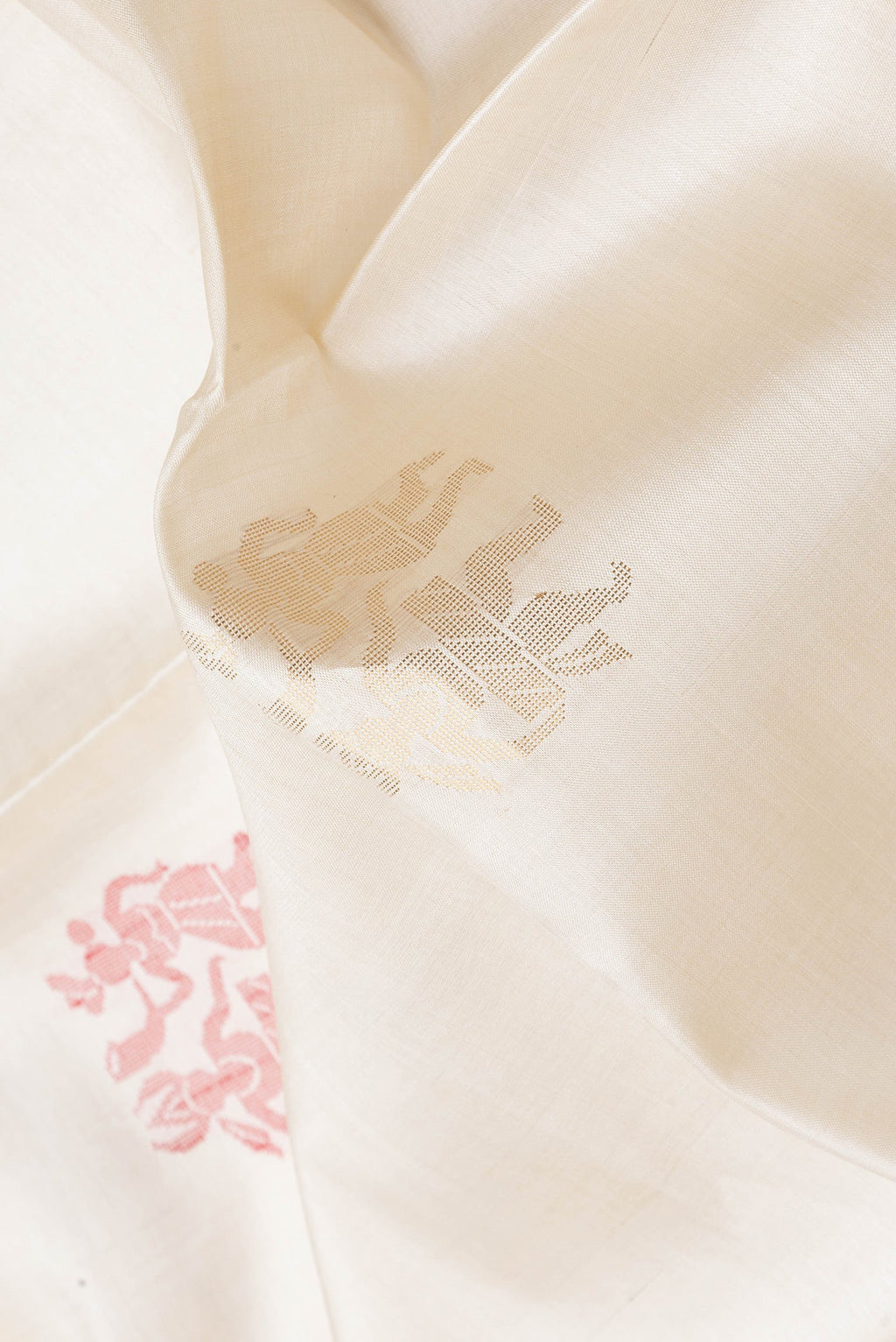 Close up of Cream Tussar Silk Saree with Zari And Thread Butta on the body and Zari Border.  displaying folds