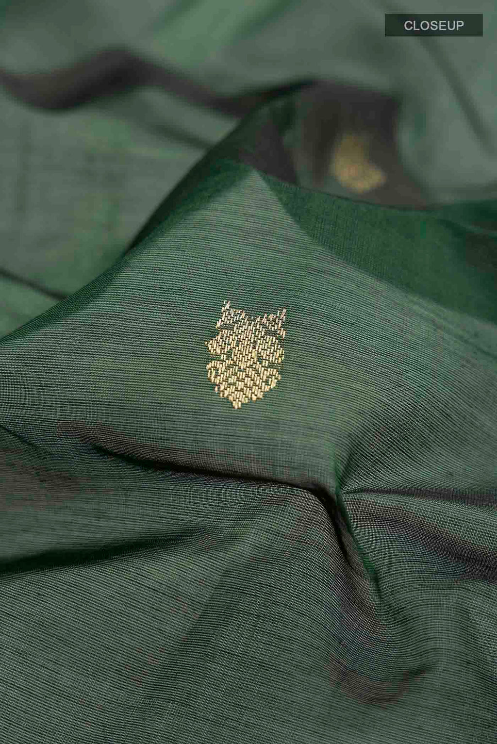 Close up of Green Silk Cotton Saree with Zari Butta on the body and Zari Border displaying folds