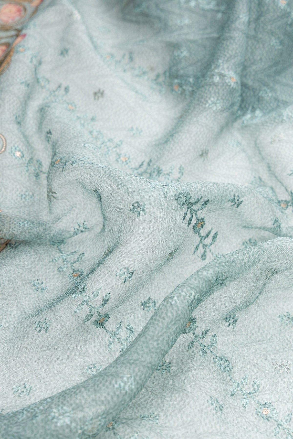Close up of Maya Blue Dual Tone Organza Silk Saree with Embroidery on the body and Embroidery Border.  displaying folds