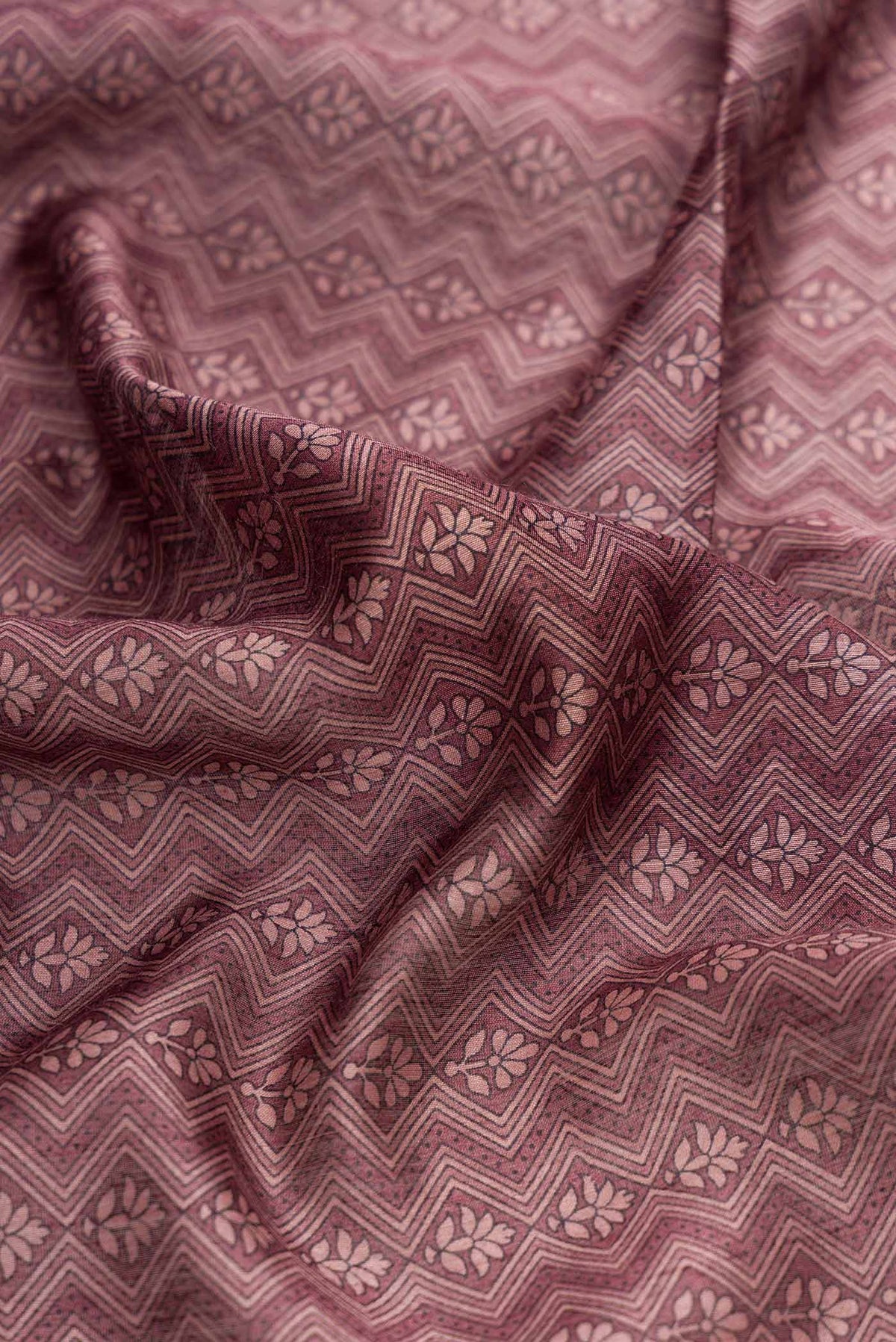 Close up of Burgundy Dual Tone Tussar Silk Saree with Printed design on the body and Zari Border displaying folds