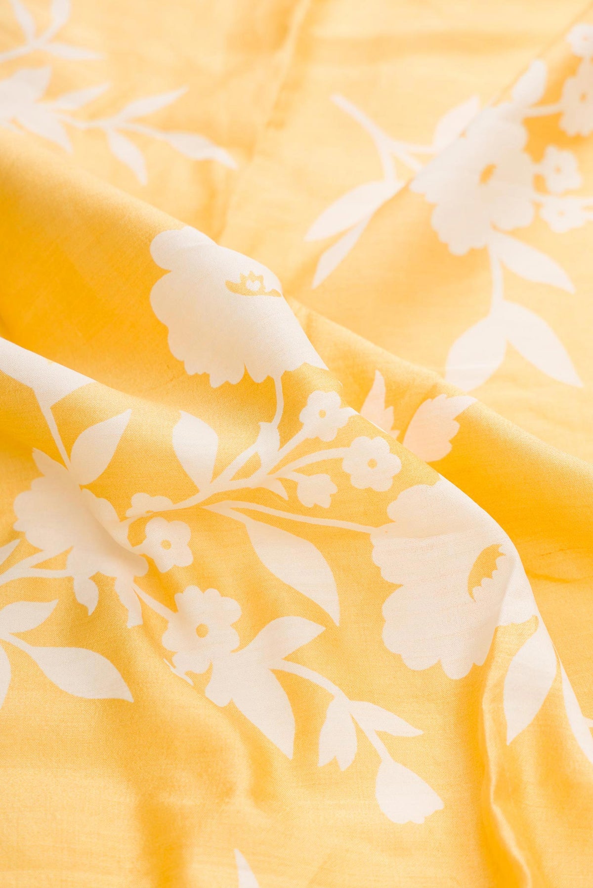 Close up of Yellow Dual Tone Tussar Silk Saree with Printed design on the body and Zari Border displaying folds