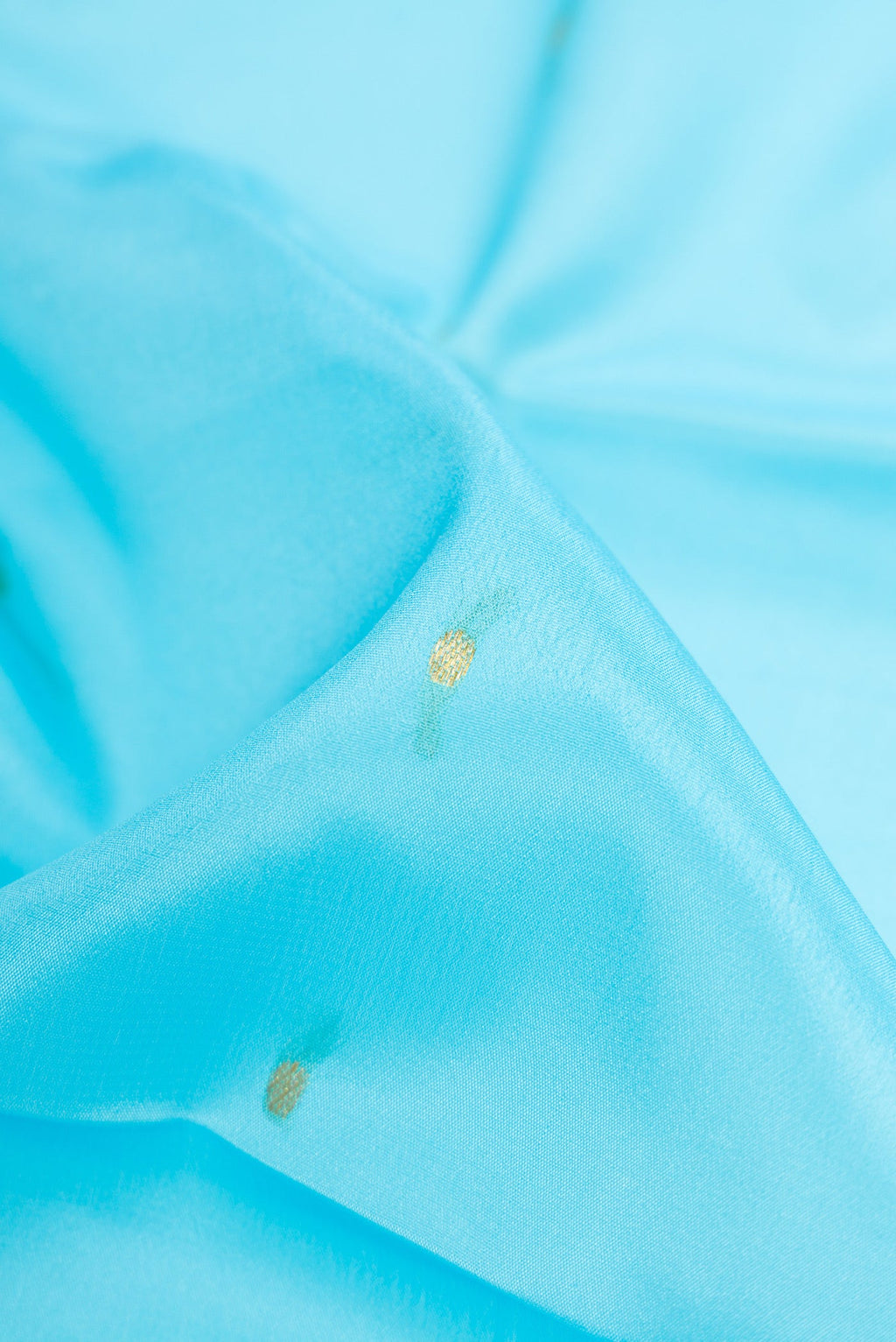 Close up of Sky Blue Mysore Crepe Saree with Zari Butta on the body and Zari Border.  displaying folds