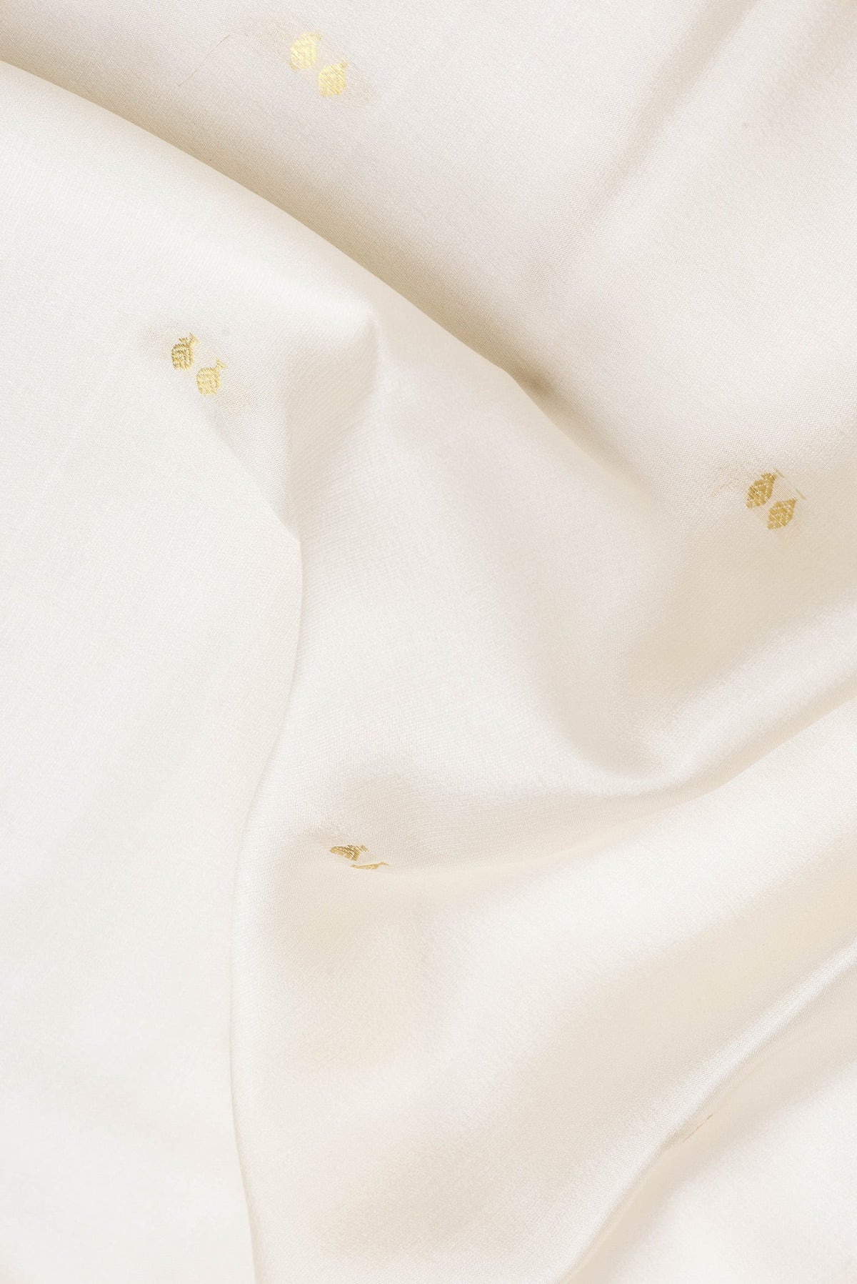 Close up of Beige Dual Tone Mysore Silk Saree with Zari Butta on the body and Zari Border.  displaying folds