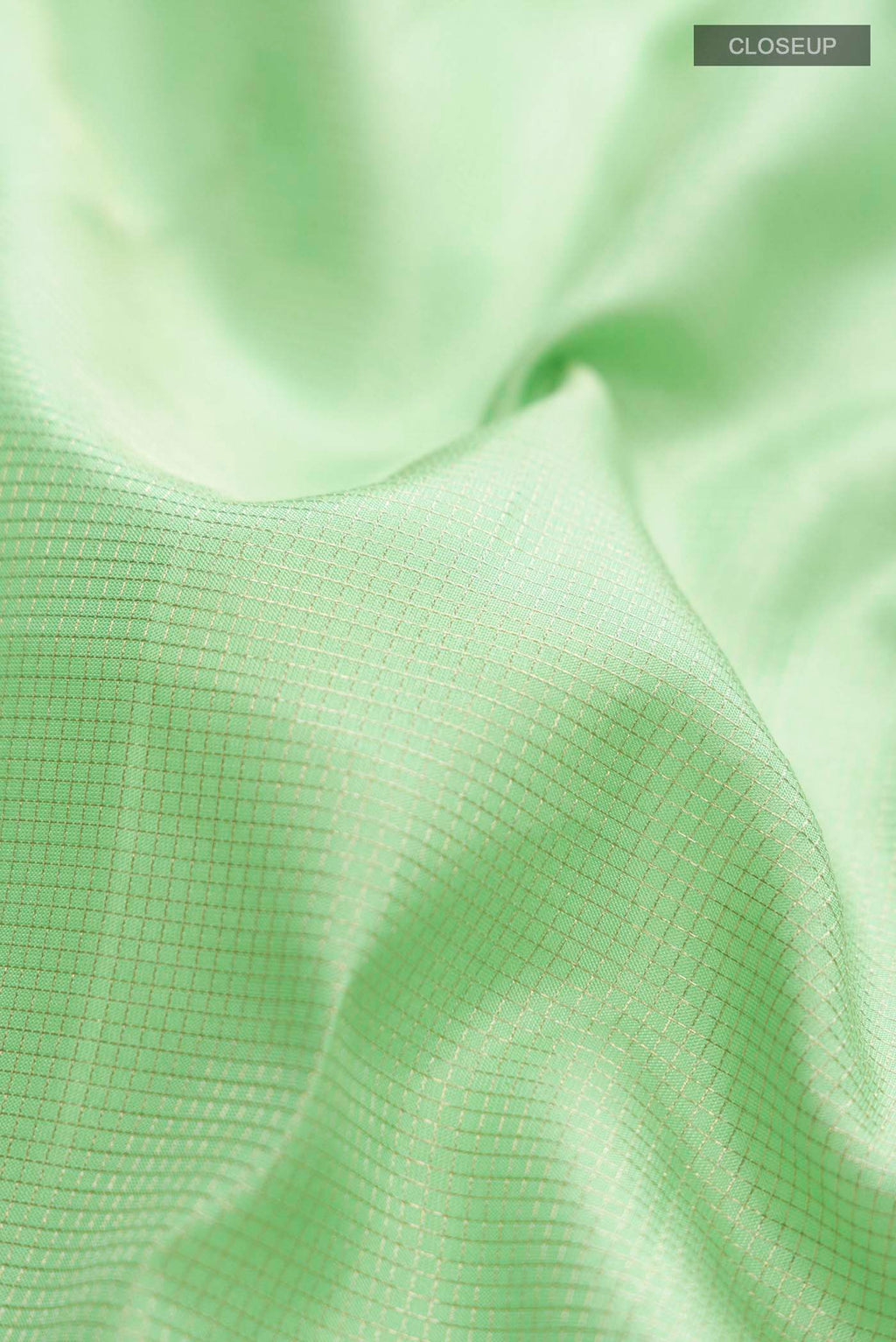 Close up of Green Kanchipuram Silk Saree with Checked design on the body and Zari Border displaying folds