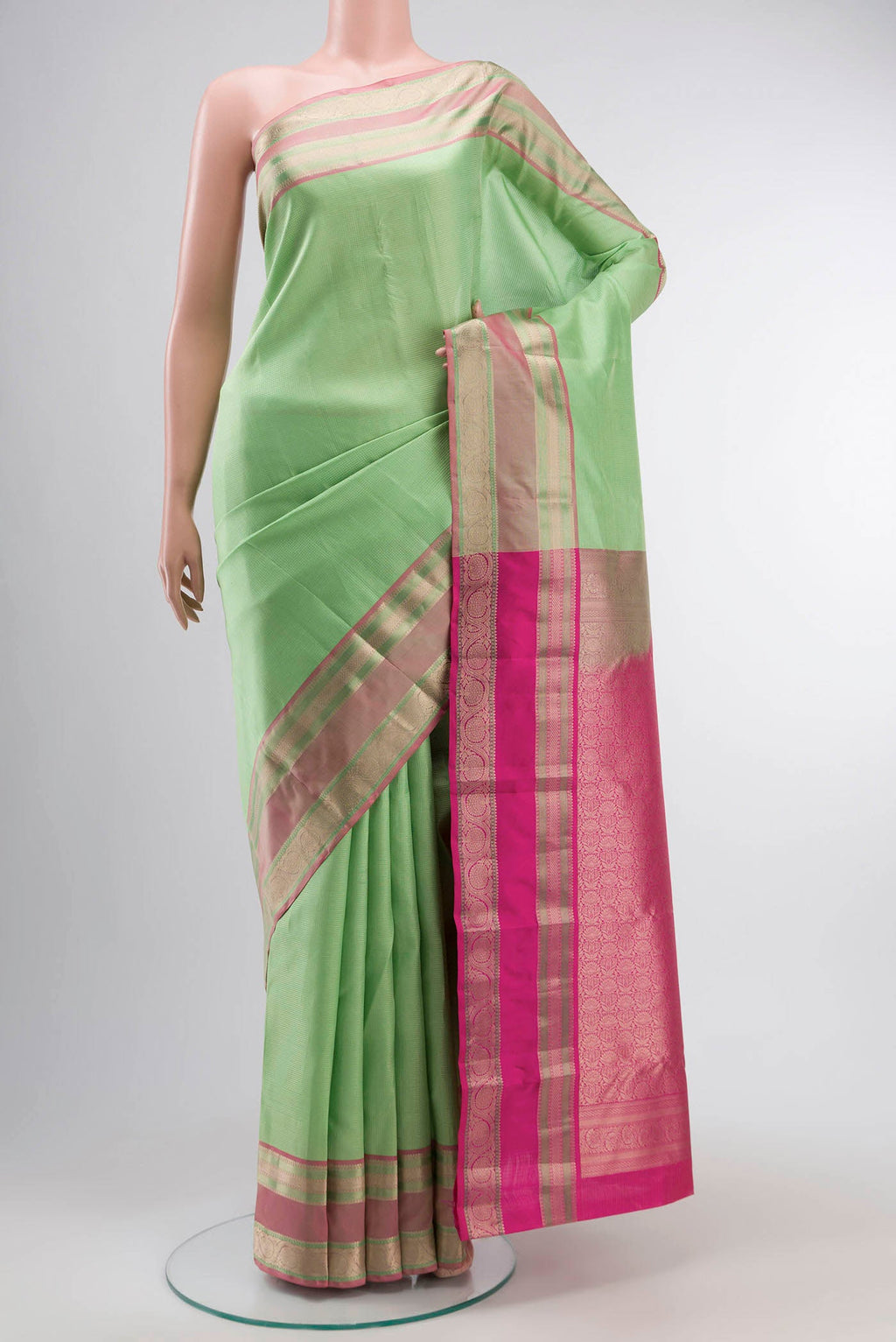 Green Kanchipuram Silk Saree with Checked design on the body and Zari Border displayed on a mannequin