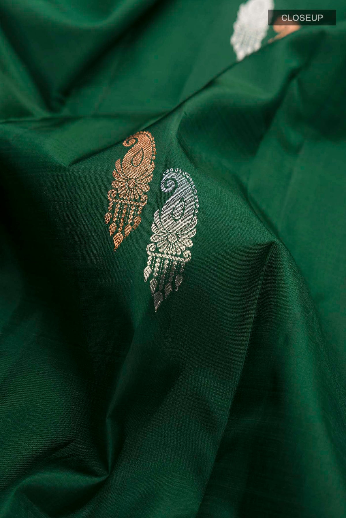Close up of Green Kanchipuram Silk Saree with Zari Butta on the body and Zari Border displaying folds