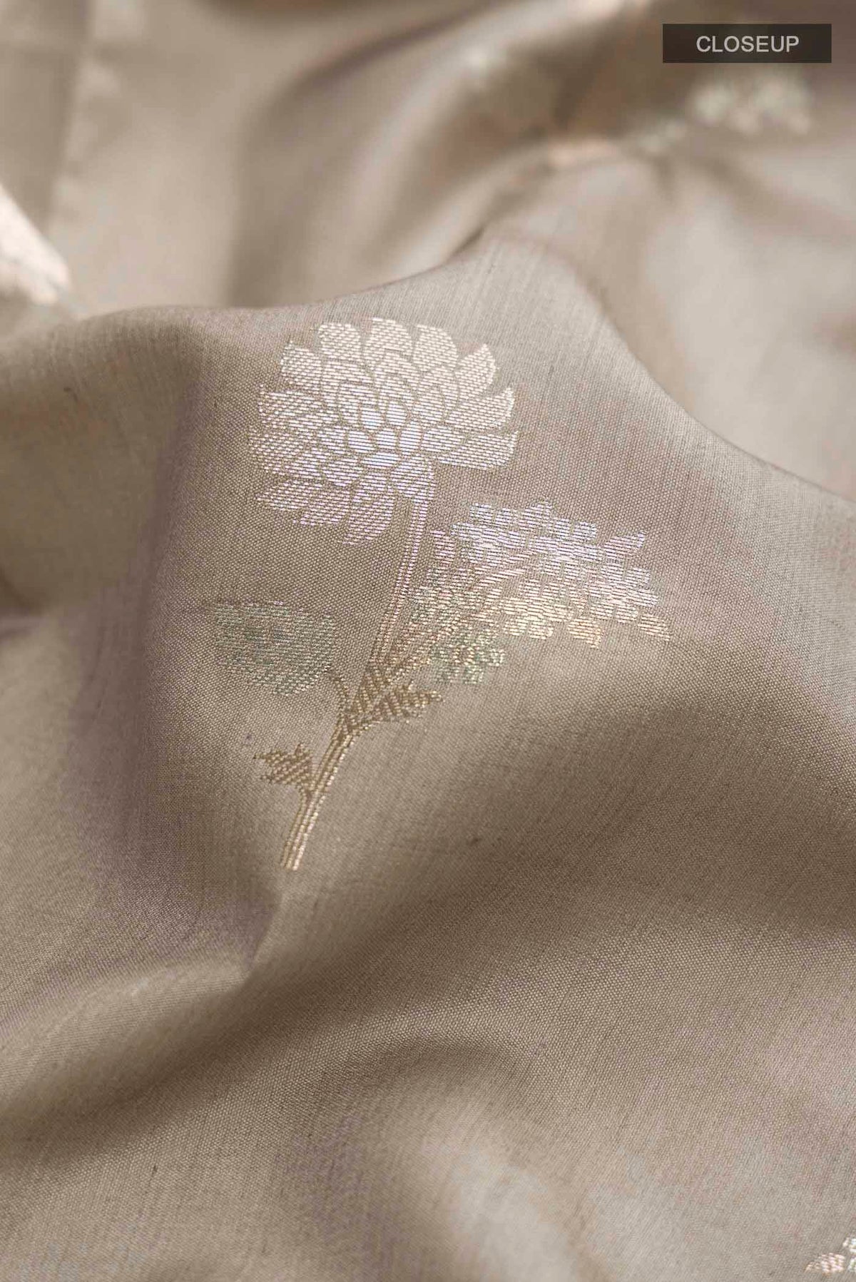 Close up of Grey Banarasi Raw Silk Saree with Zari Butta on the body and Zari Border displaying folds