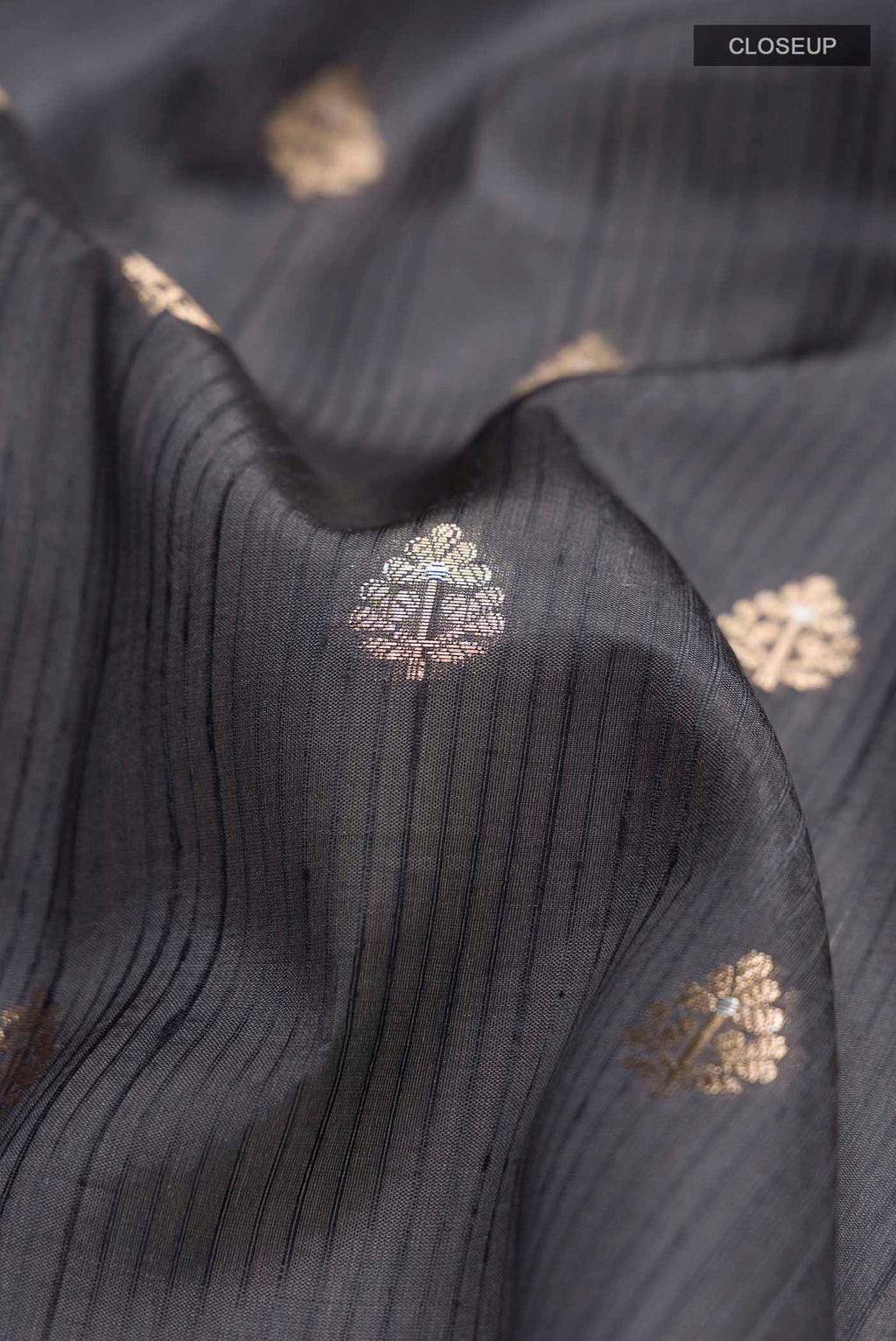 Close up of Grey Banarasi Raw Silk Saree with Zari Butta on the body and Zari Border displaying folds