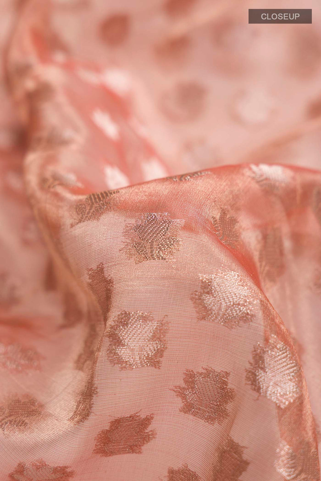 Close up of Orange Banarasi Tissue Silk Saree with Zari Butta on the body and Zari Border displaying folds