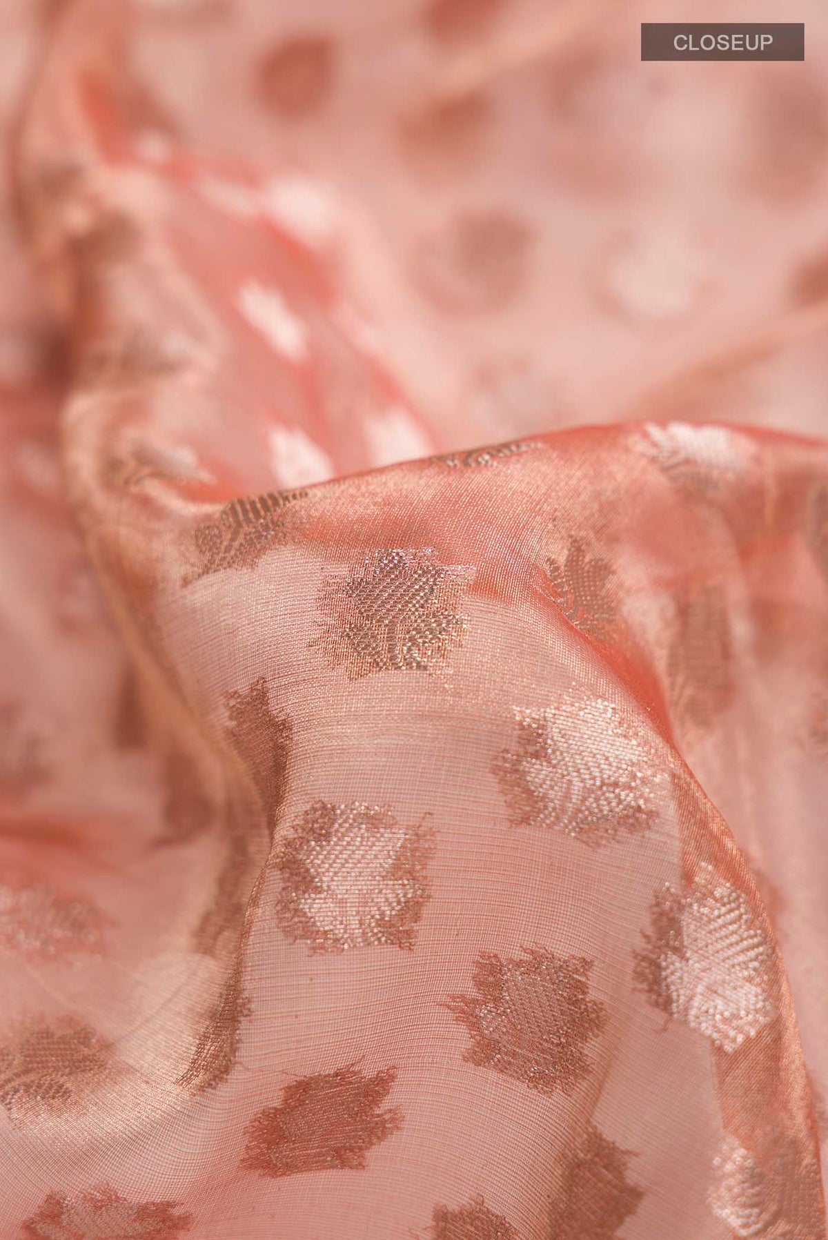 Close up of Orange Banarasi Tissue Silk Saree with Zari Butta on the body and Zari Border displaying folds