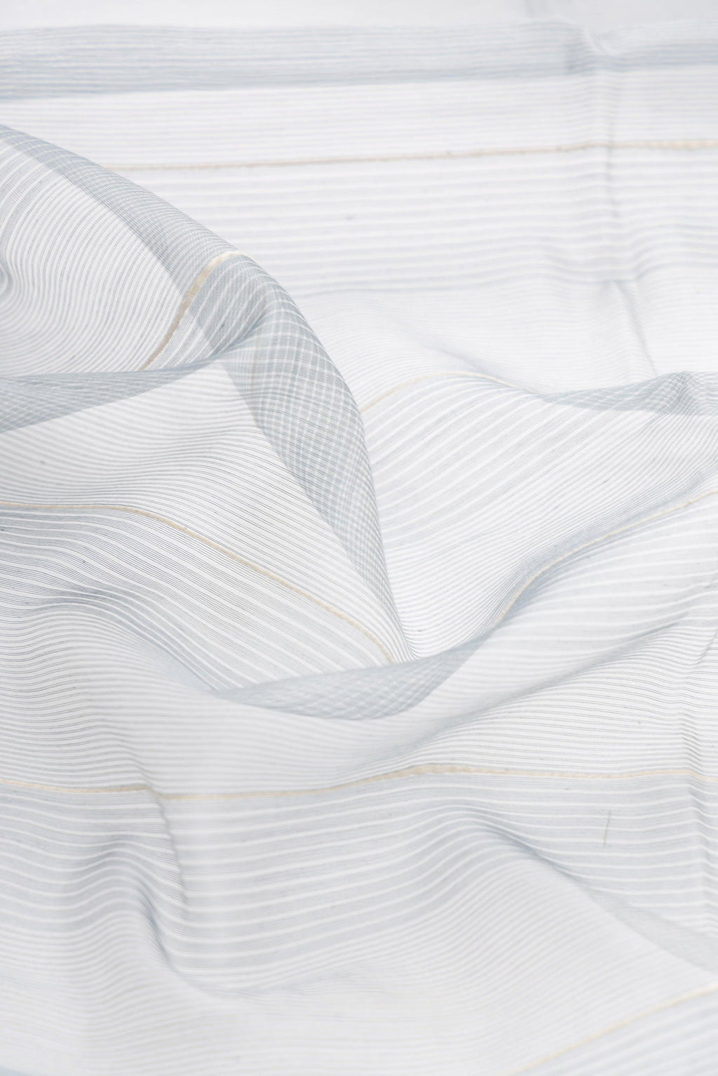 Close up of Grey Dual Tone Silk Cotton Saree with Stripes on the body and Zari Border displaying folds