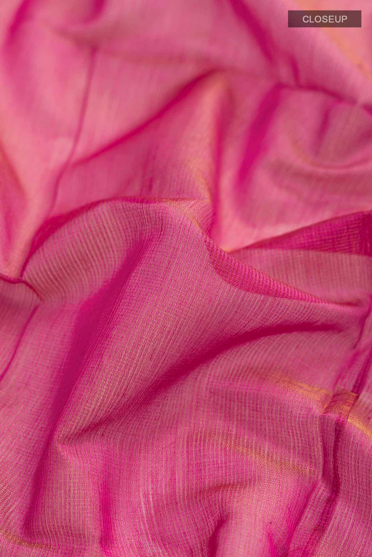 Close up of Pink Maheshwari Silk Cotton Saree with Checked design on the body and Zari Border displaying folds