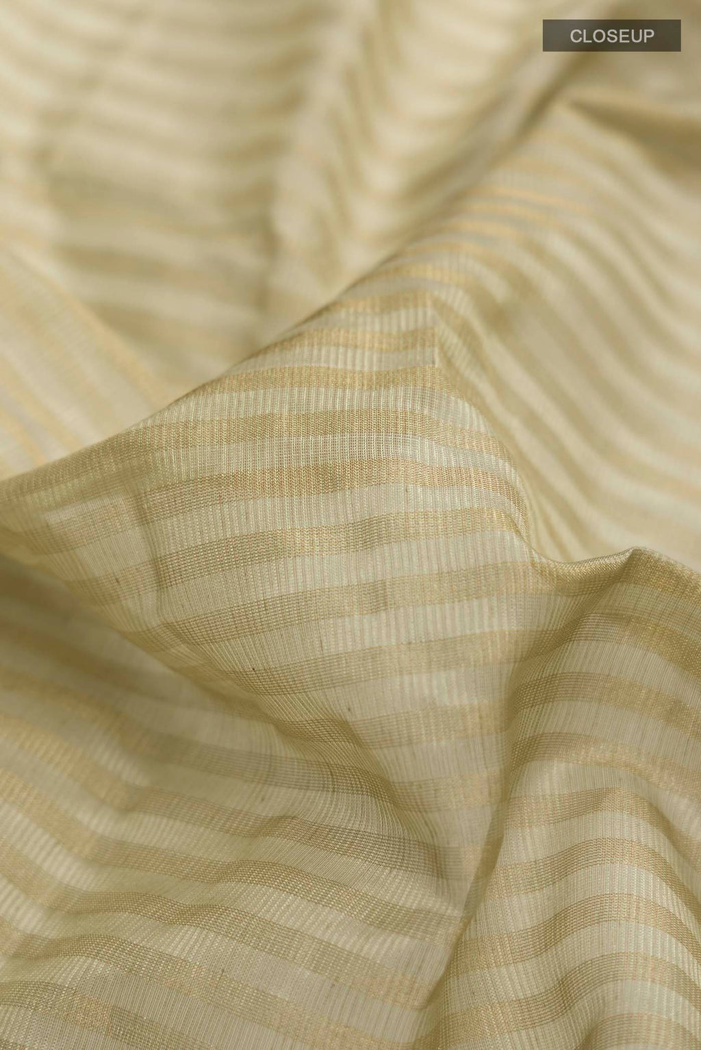 Close up of Sage Green Maheshwari Silk Saree with Stripes on the body and Zari Border displaying folds
