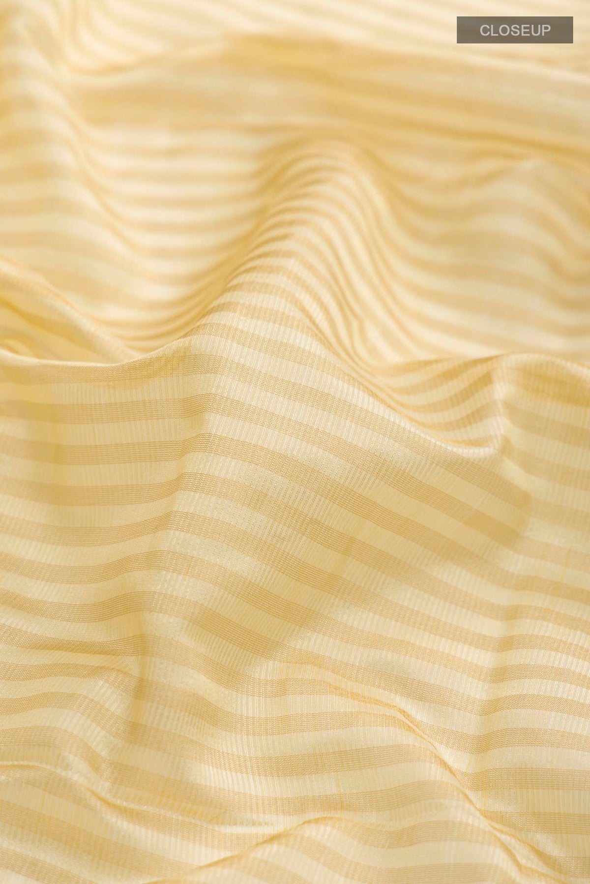 Close up of Cream Banarasi Raw Silk Saree with Stripes on the body and Zari Border displaying folds