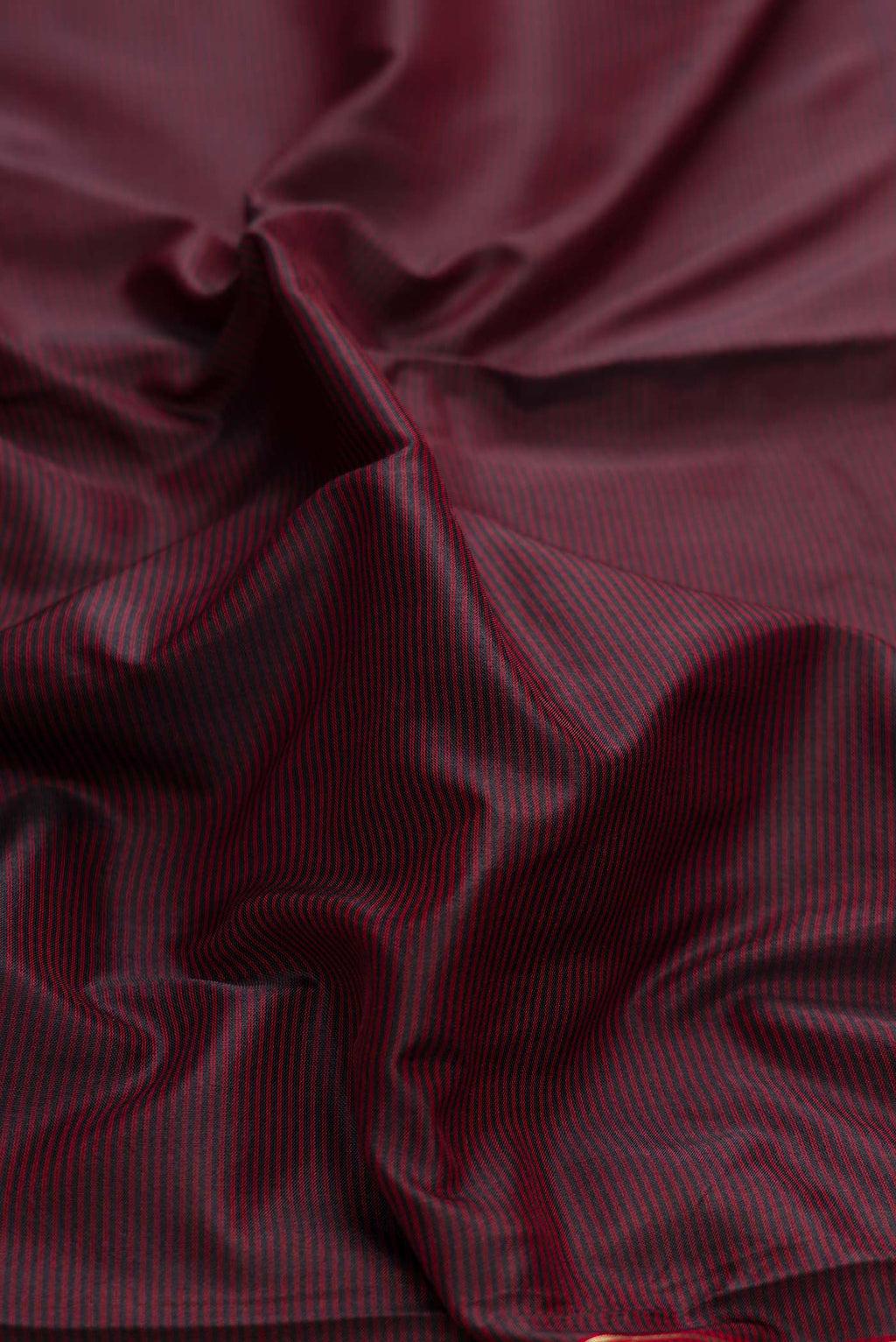 Close up of Brown Dual Tone Maheshwari Silk Saree with Stripes on the body and Zari Border displaying folds