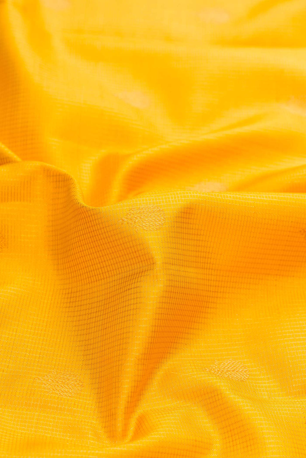 Close up of Yellow Dual Tone Kanchipuram Silk Saree with Zari Butta on the body and Zari Border displaying folds