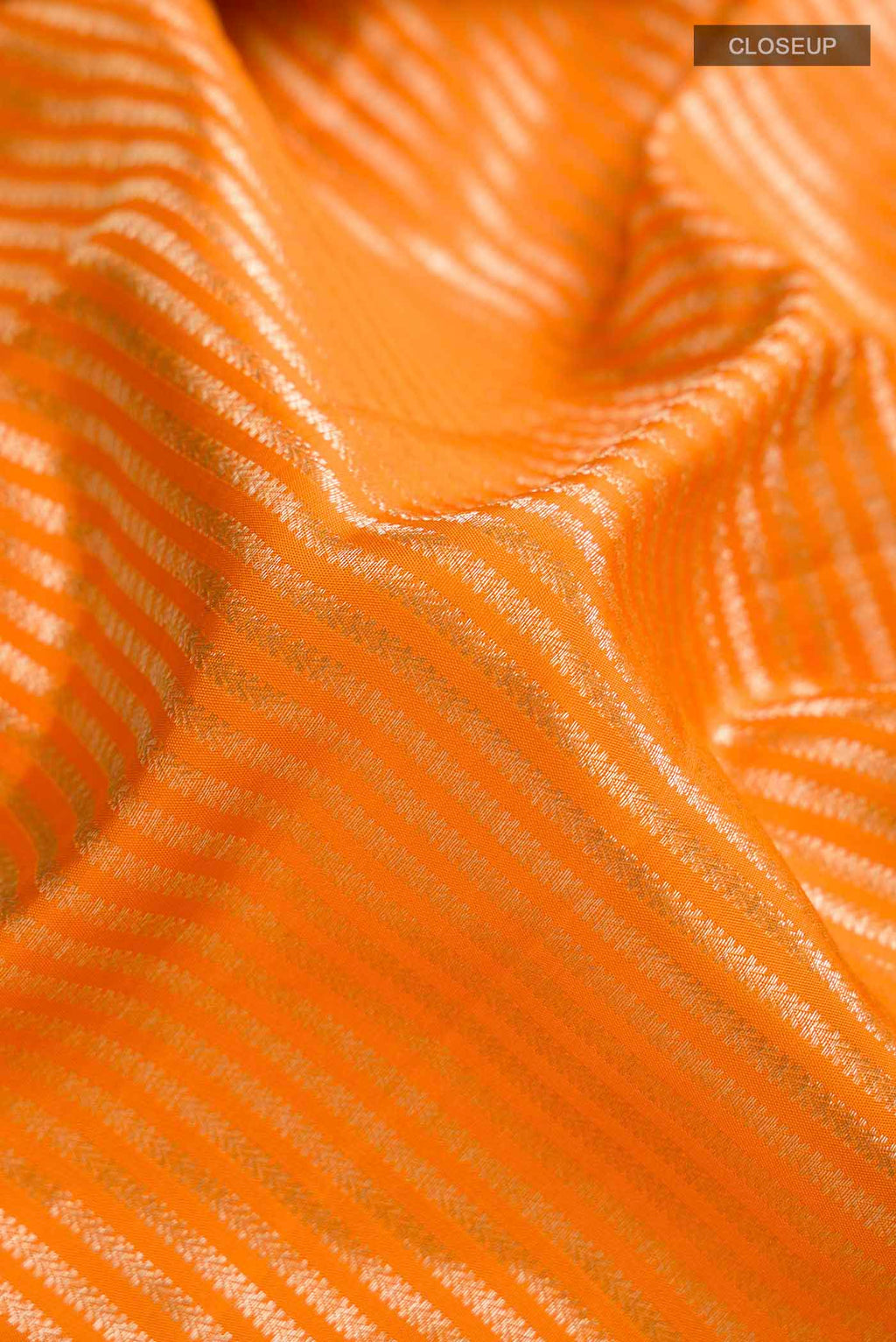 Close up of Orange Kanchipuram Silk Saree with Stripes on the body and Zari Border displaying folds