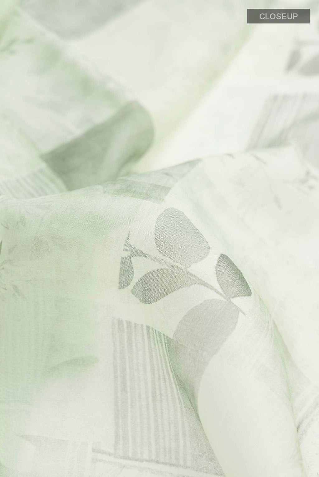 Close up of Green Organza Silk Saree with Printed design on the body and Plain Border displaying folds