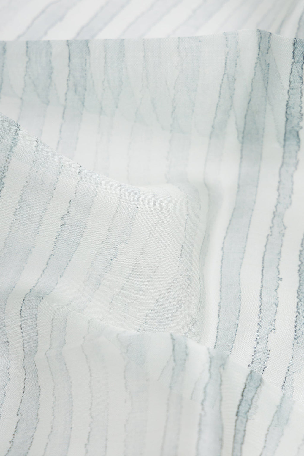 Close up of Grey Dual Tone Organza Silk Saree with Printed design on the body and Zari Border.  displaying folds